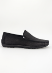 Profile shot of a black Shuclub slip-on shoe with intricate perforated patterns.