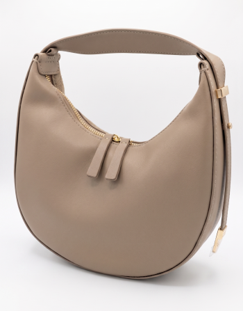 A nude beige smooth leather crescent-shaped hobo shoulder bag by SHUCLUB, showcasing a minimalist curved silhouette, dual top zippers with leather pull tabs, and polished gold hardware accents on the side strap, shot against a solid white studio background.