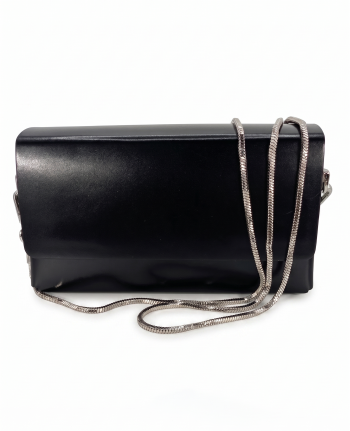 Front View with Chain: Onyx black smooth leather box clutch bag by SHUCLUB, featuring a structured rectangular design, a clean minimalist front flap, and a polished silver-tone snake chain strap draped across the front face. Side & Back Detail View: Side and reverse profile angle of the structured black SHUCLUB clutch bag, showcasing its architectural box shape, silver-tone side hardware attachments, and flat-head silver metal stud accents on the back.
