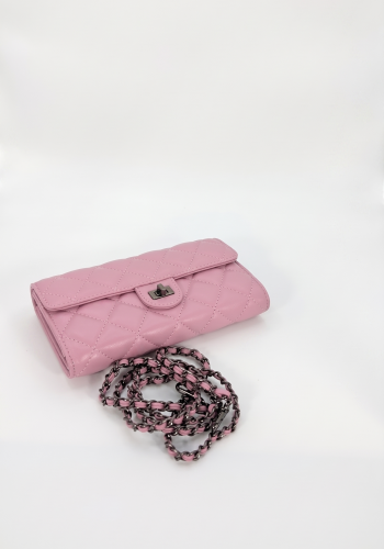 Pink quilted leather crossbody bag by SHUCLUB featuring a classic diamond pattern, a turn-lock clasp, and an intertwined gunmetal chain strap, shot on a clean white background.