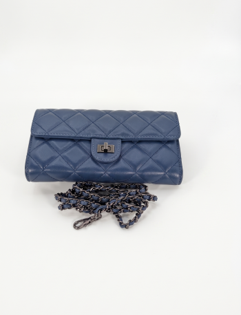 Navy blue quilted leather crossbody bag by SHUCLUB, featuring a structured diamond pattern, a polished gunmetal turn-lock clasp, and a matching intertwined chain strap, displayed on a clean white background.
