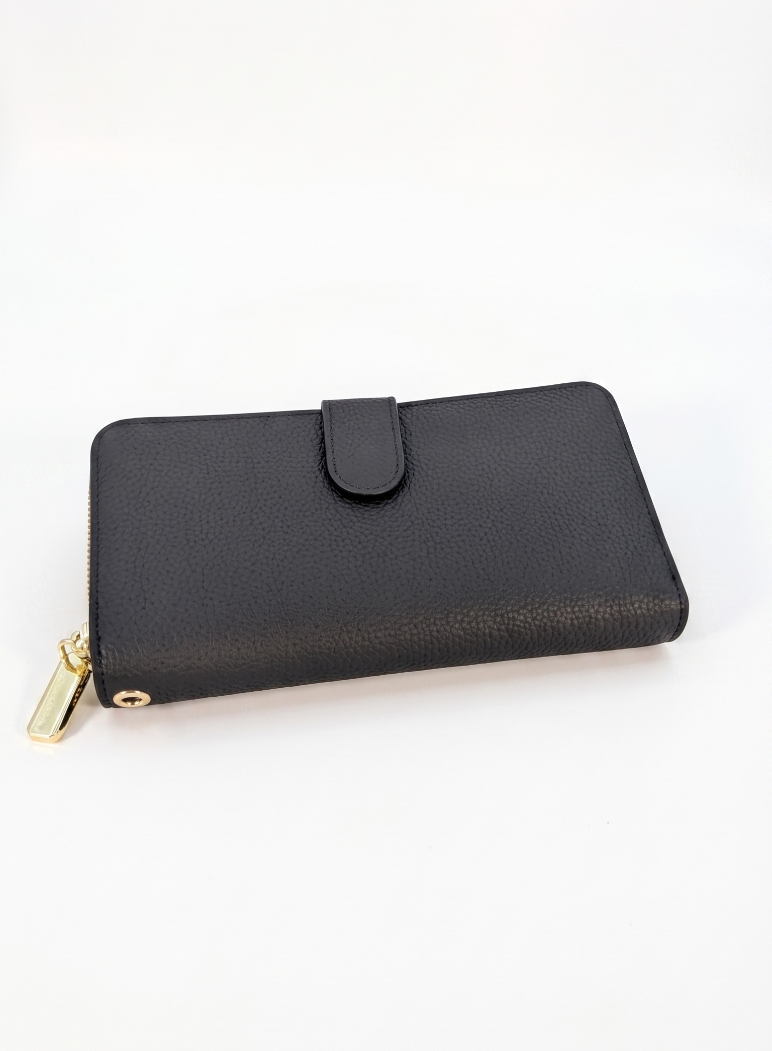 SHUCLUB Luxury Pebbled Leather Zip-Around Continental Wallet – Onyx Black Front View with Clasp: Onyx black pebbled leather continental wallet by SHUCLUB, featuring a fine grain texture, a secure fold-over snap button tab, and a polished gold-tone wraparound zipper, shot on a solid white background. Minimalist Back View: Rear studio view of the black pebbled leather continental wallet, highlighting its clean, seamless construction and a subtle debossed geometric brand logo emblem near the center.